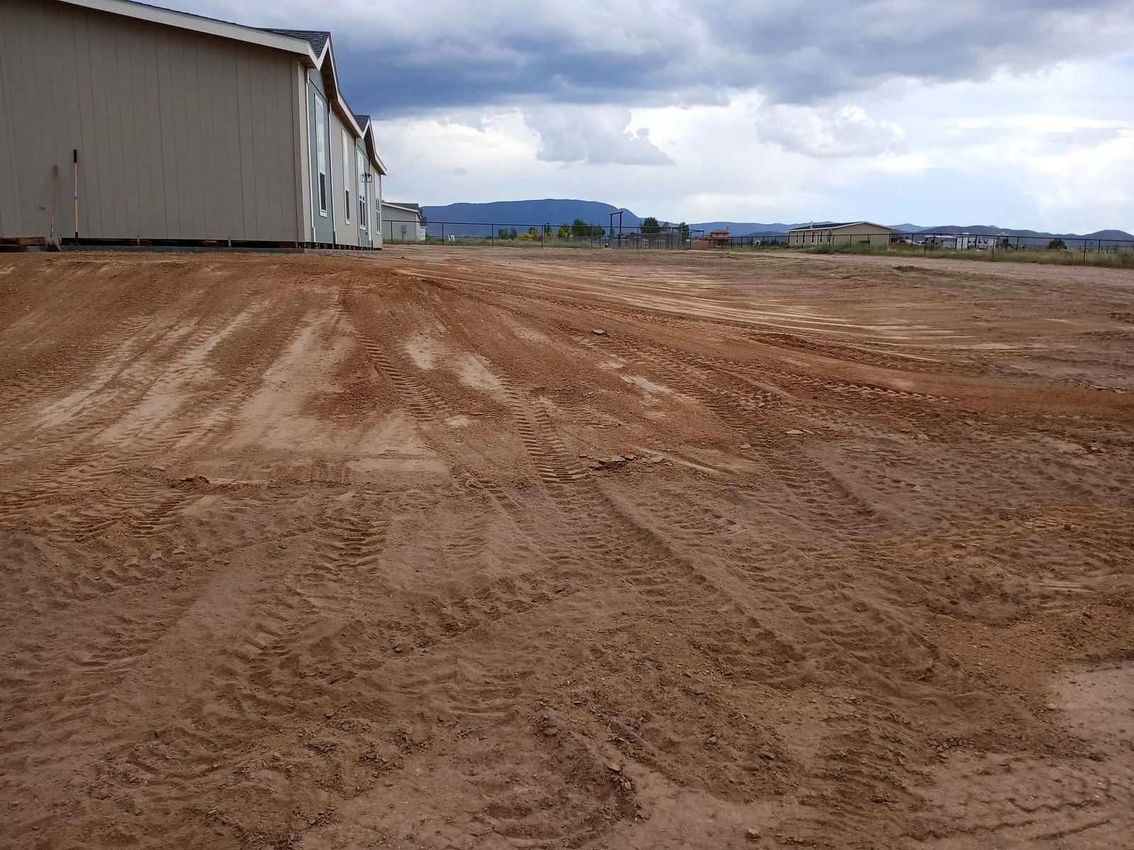 Finished graded pad beside a home with mountains behind