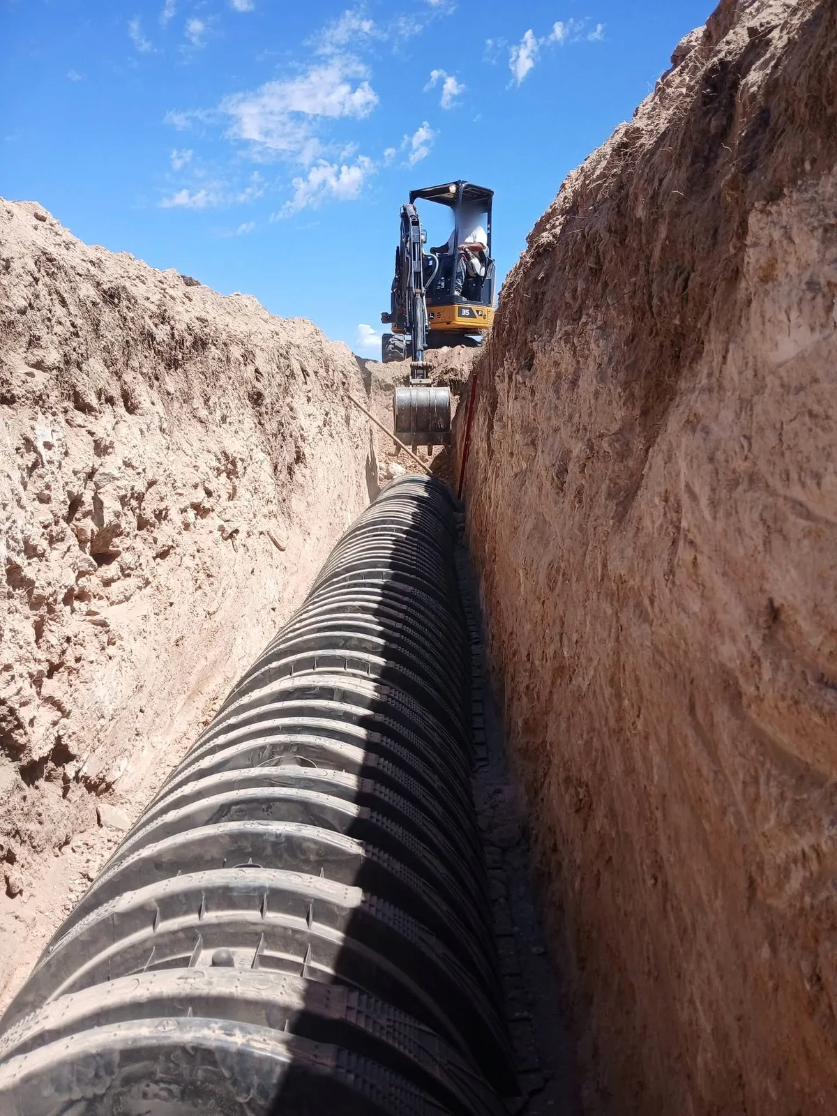 Excavator at the end of a long leach field trench