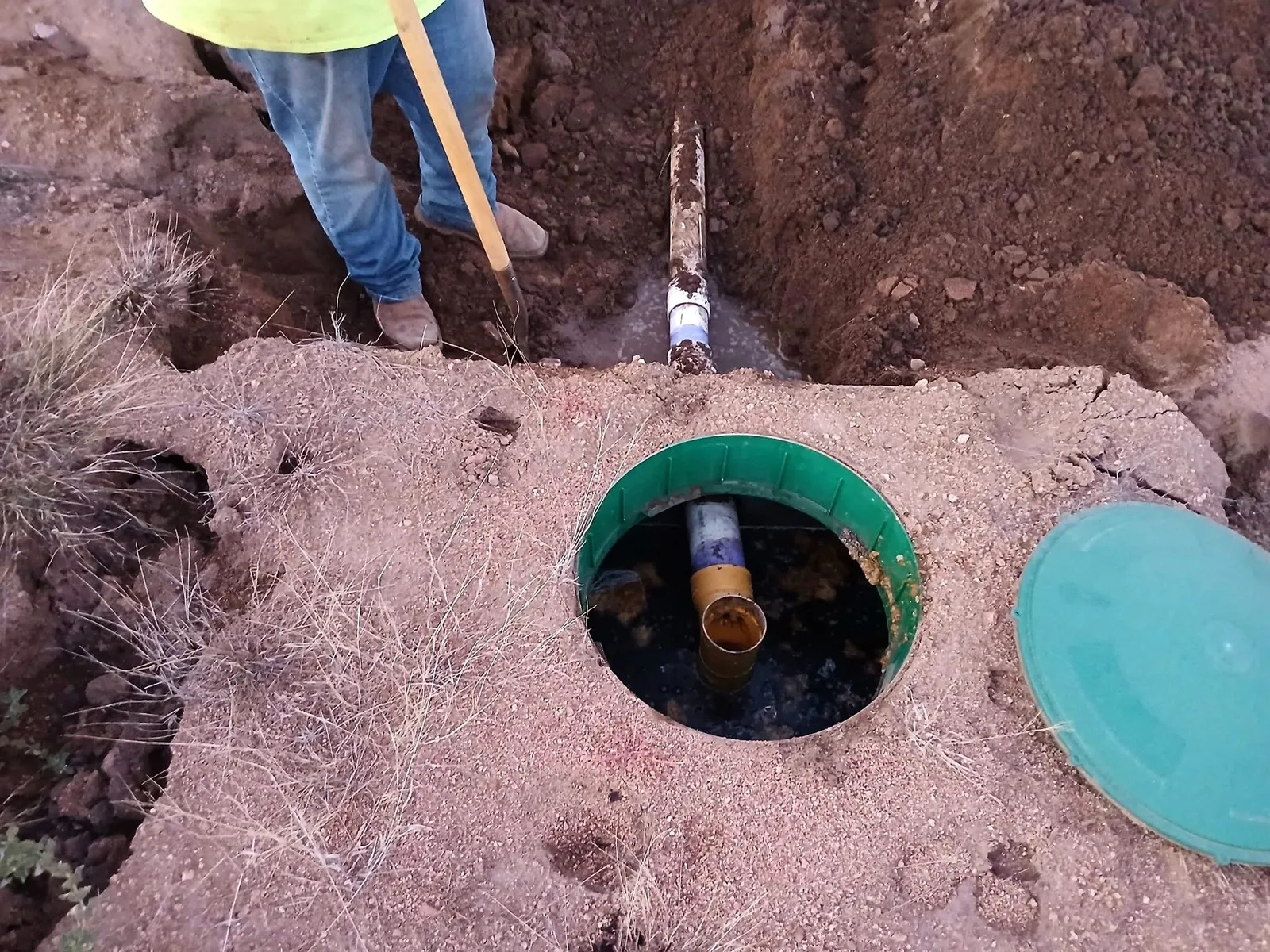Mill Iron B crew opening a septic tank riser during a line repair