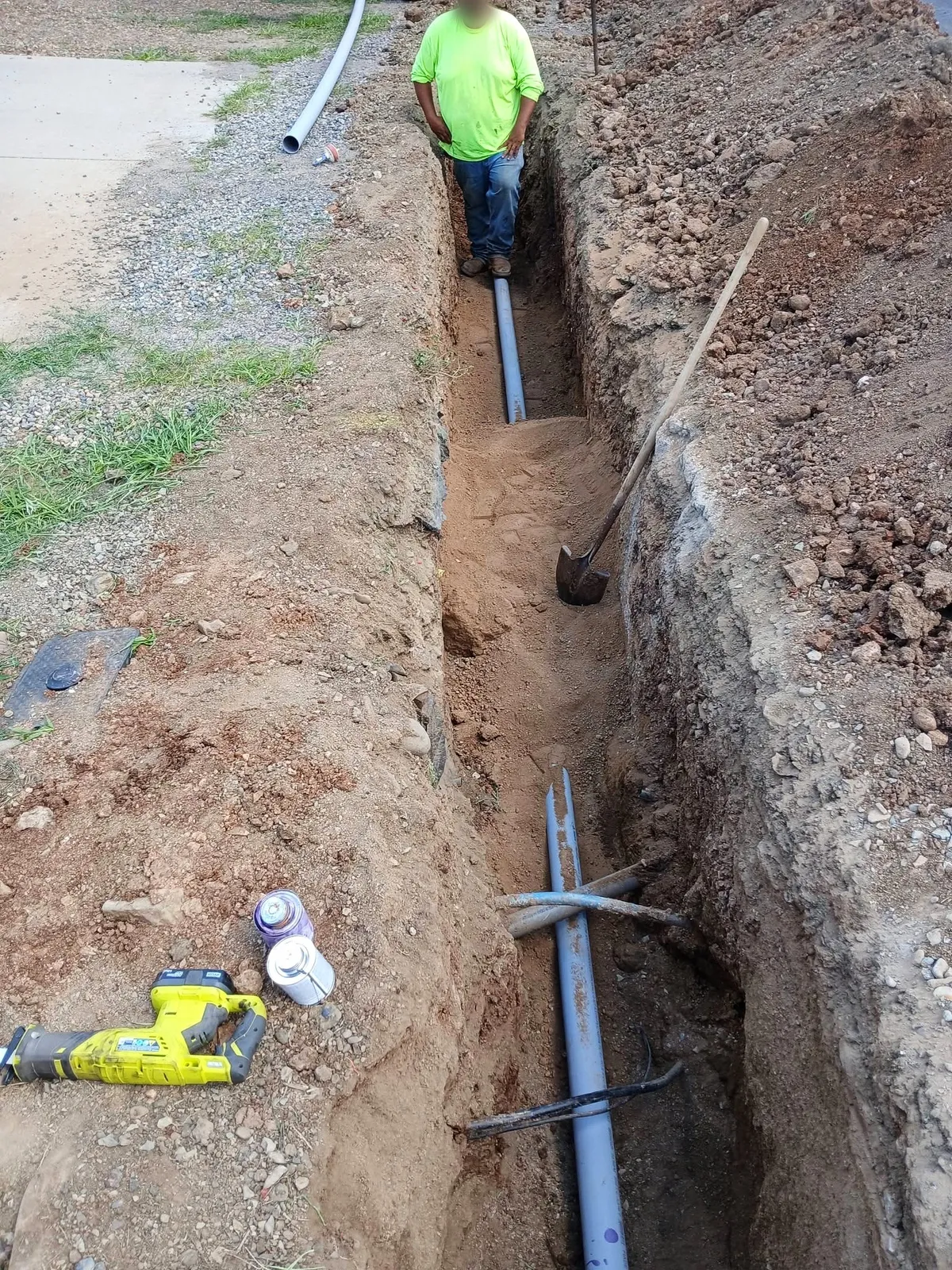 Mill Iron B crew member in a utility trench with new pipe laid